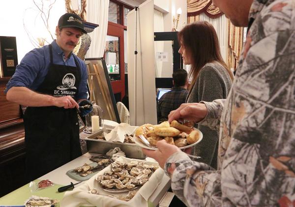 Man shucking oysters for event attendees