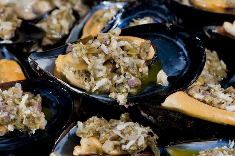 A close-up of a plate of mussels that are cooked and ready to eat. 