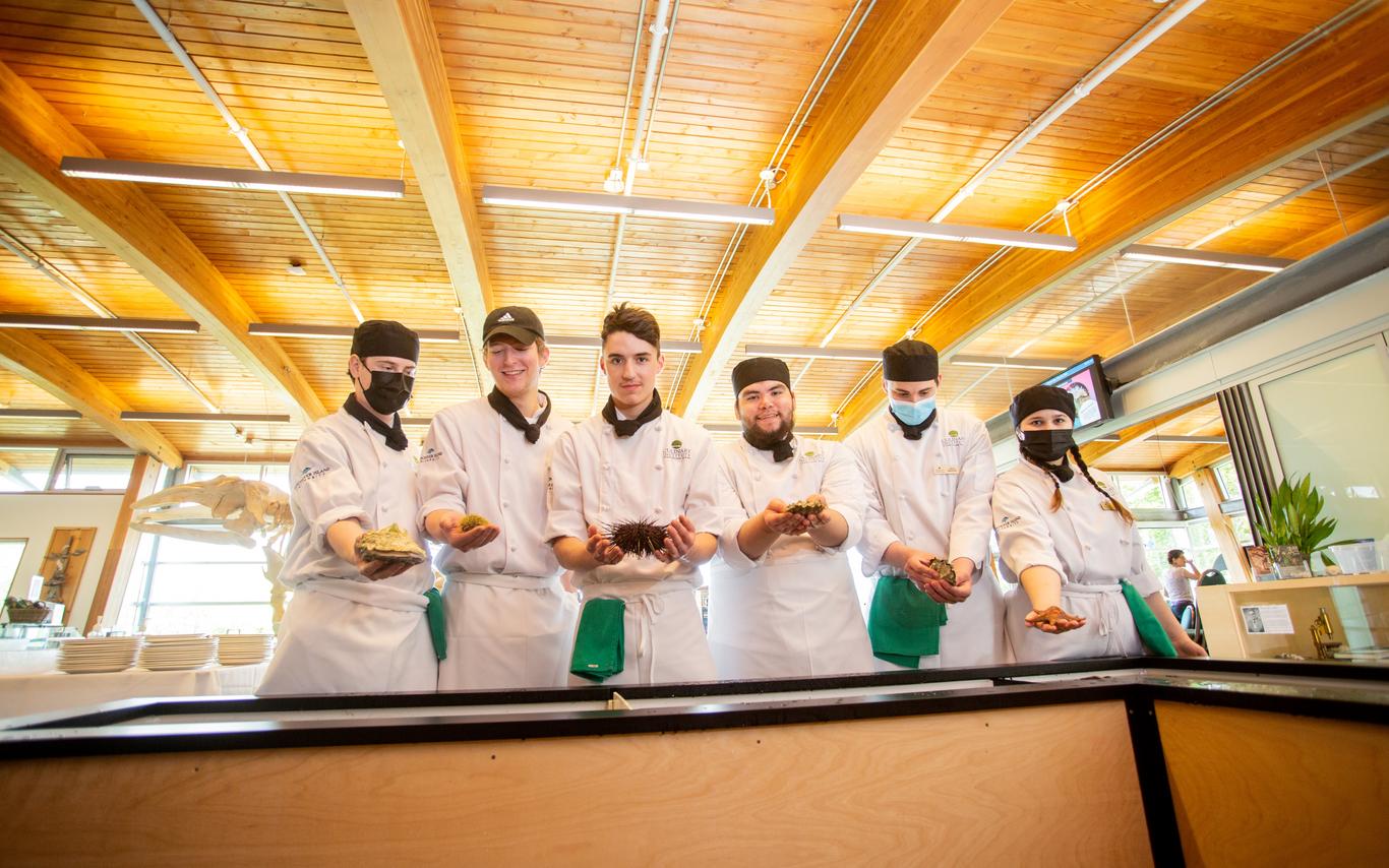 VIU culinary students holding shellfish at touch tanks